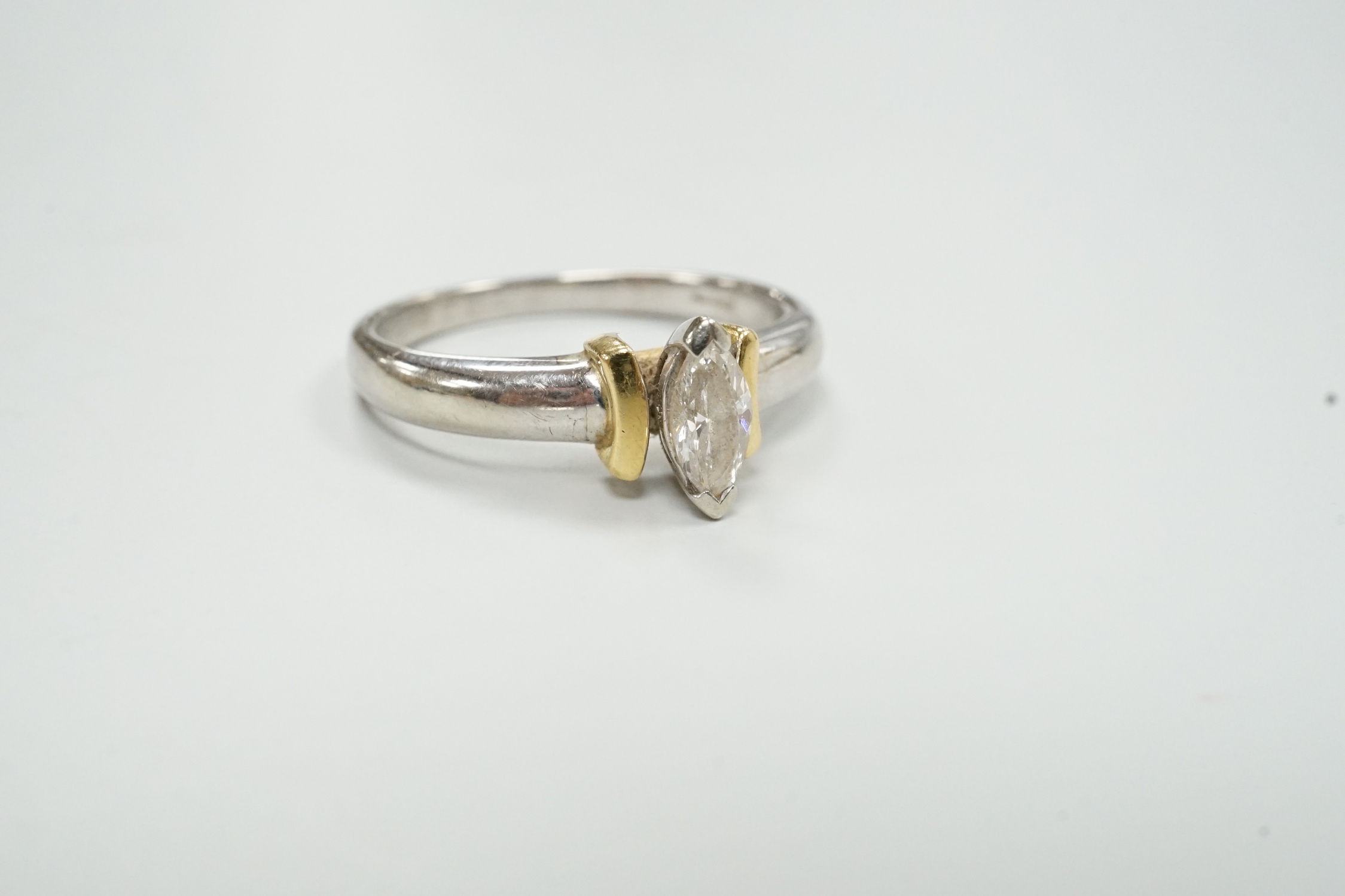 A modern two colour 18ct and solitaire marquise cut diamond set ring, size M/N, gross weight 3.6 grams.